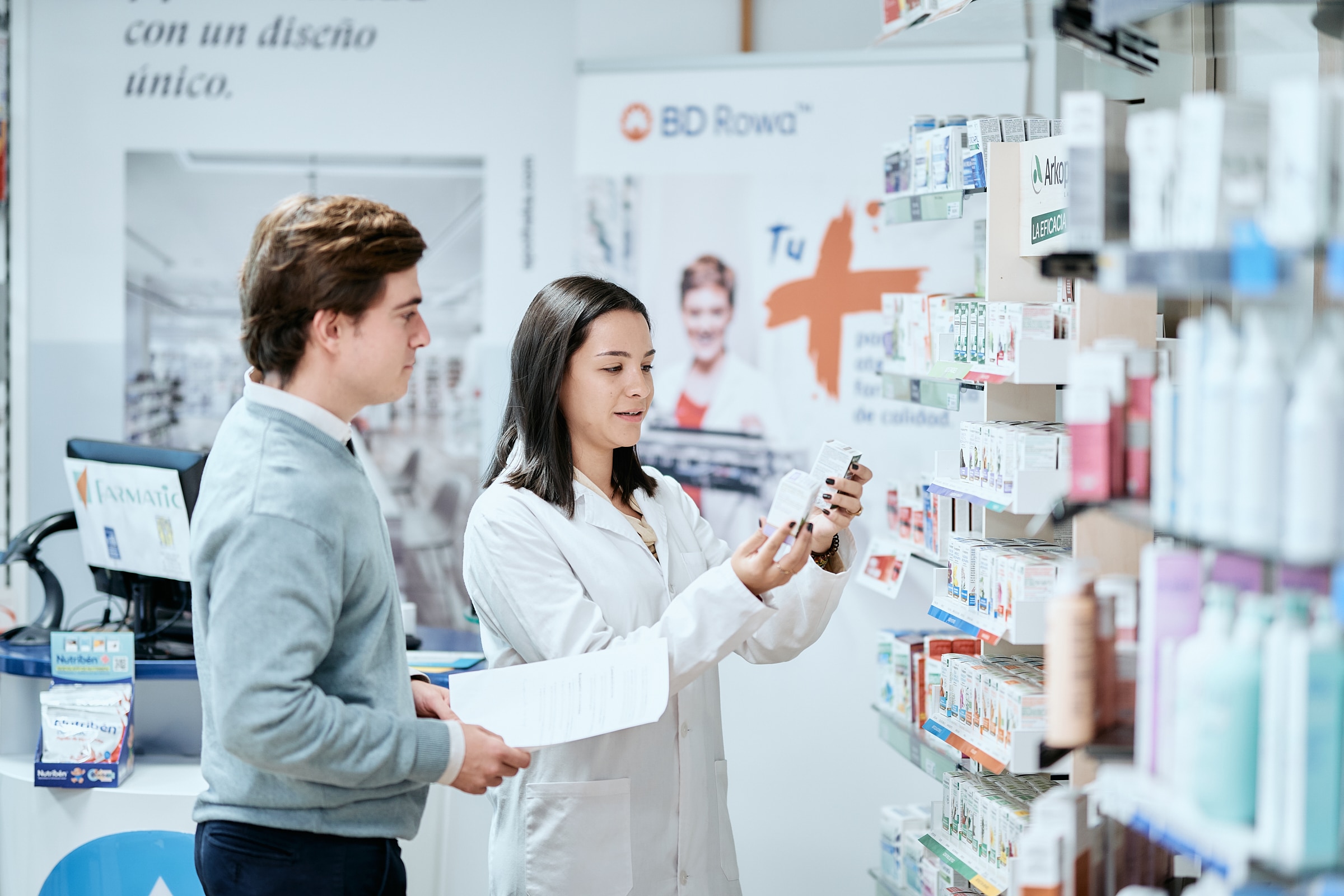 Una alumna CEU atendiendo a un cliente en la farmacia