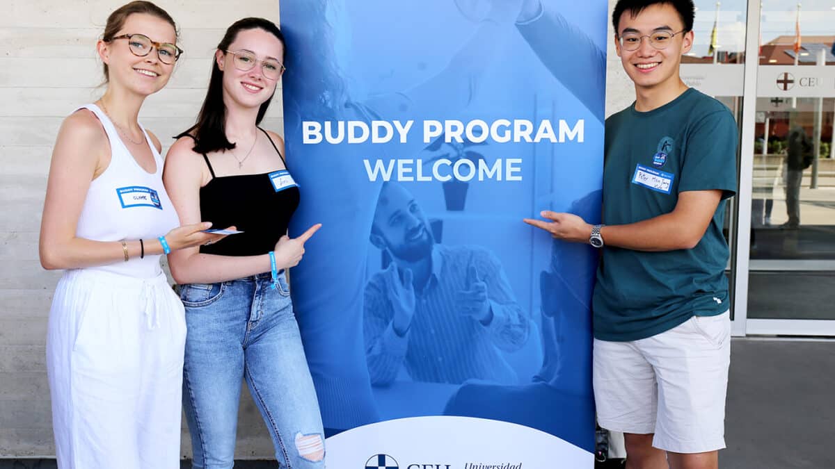 Tres alumnos posando junto a un roll up en el budy Fest celebrado en el campus de Montepríncipe